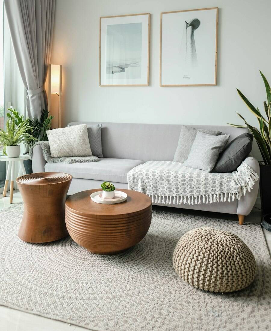 A tidy living room with a grey sofa, woven rug and framed prints.